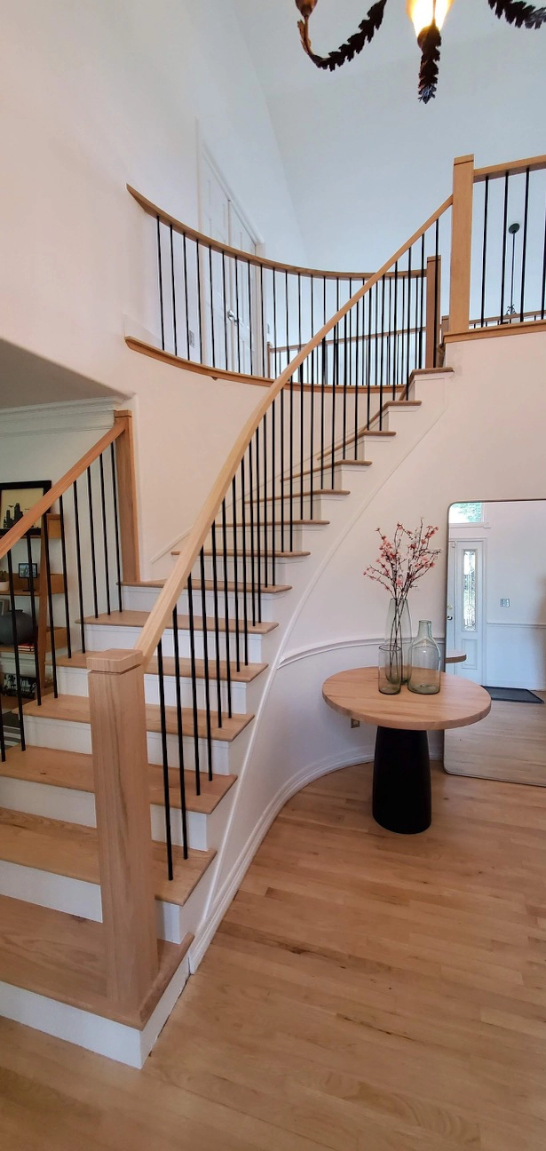 Curved wood handrail installed on interior staircase in Denver area home