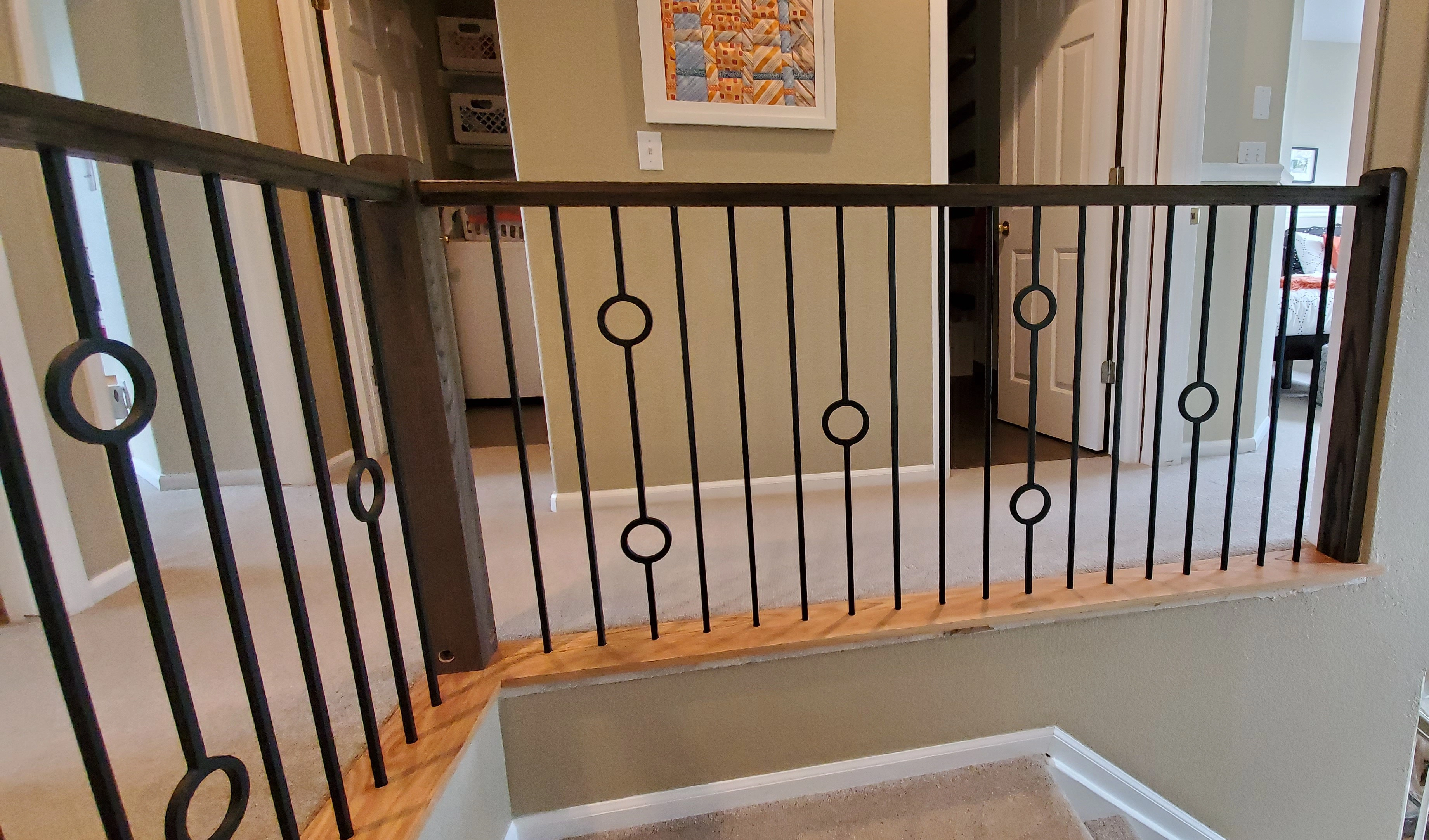 Black iron balusters with stained handrail and painted stair trim